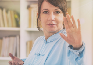 Femme pratiquant le Qi Gong en intérieur, dans un mouvement lent et concentré
