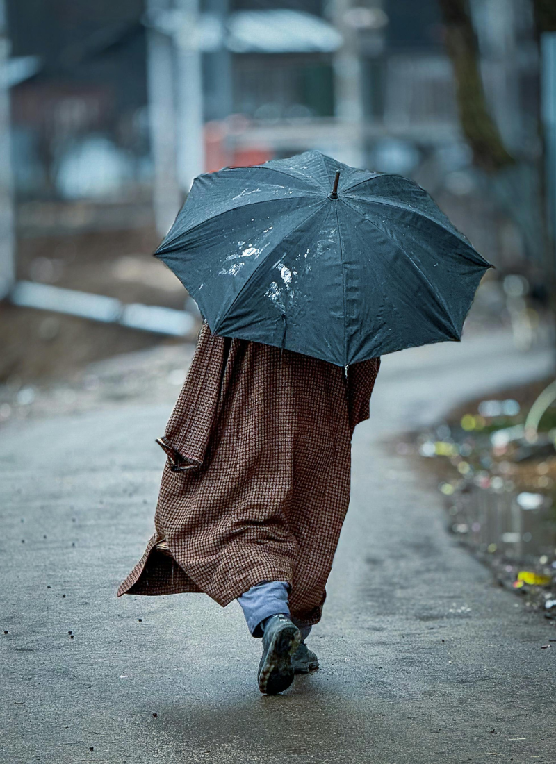 homme marchant protégé par un parapluie symbole de la connaissance de son Ba zi